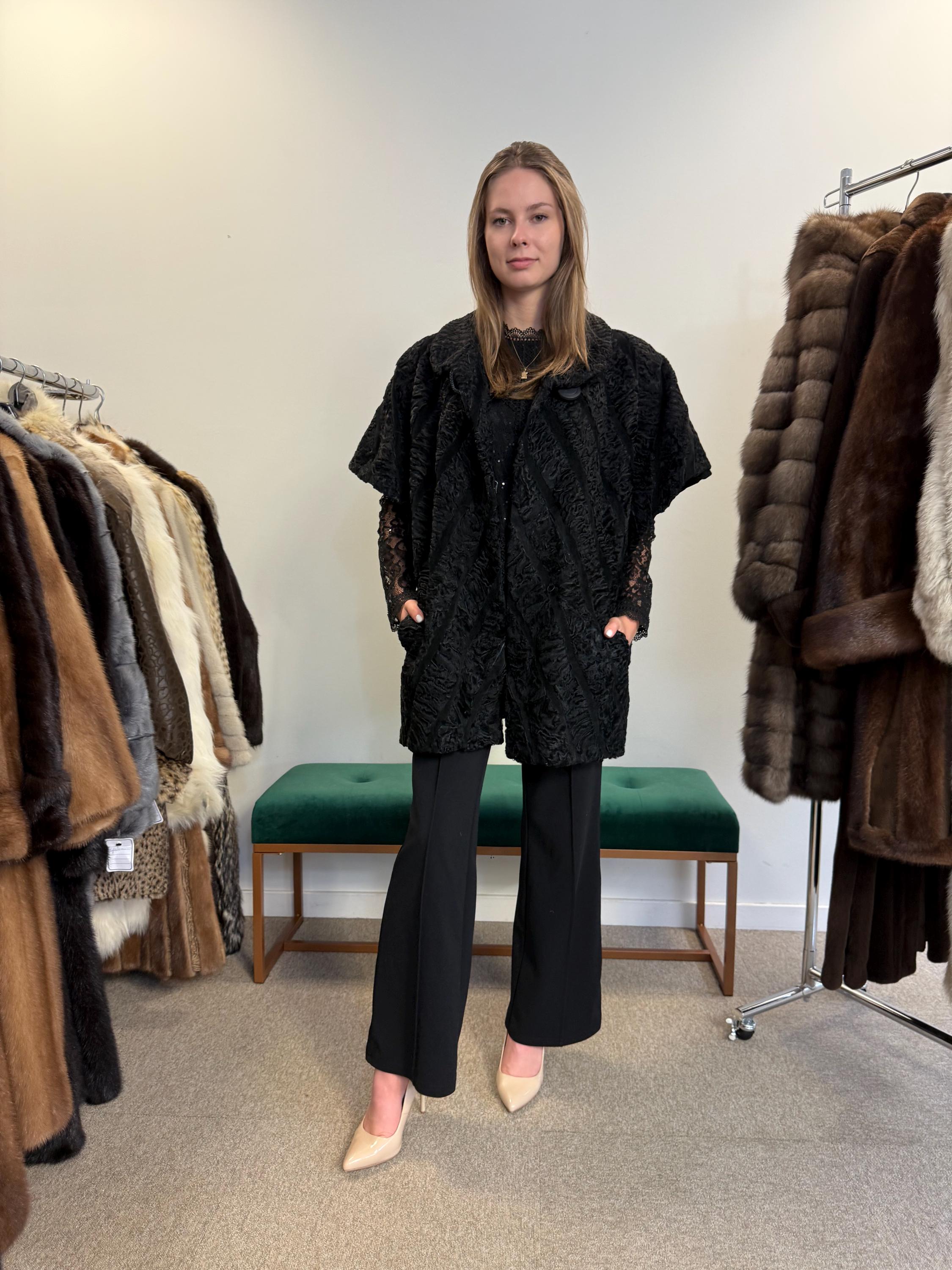 Full body view of black astrakhan fur vest worn by model, women’s soft high-quality vintage fur