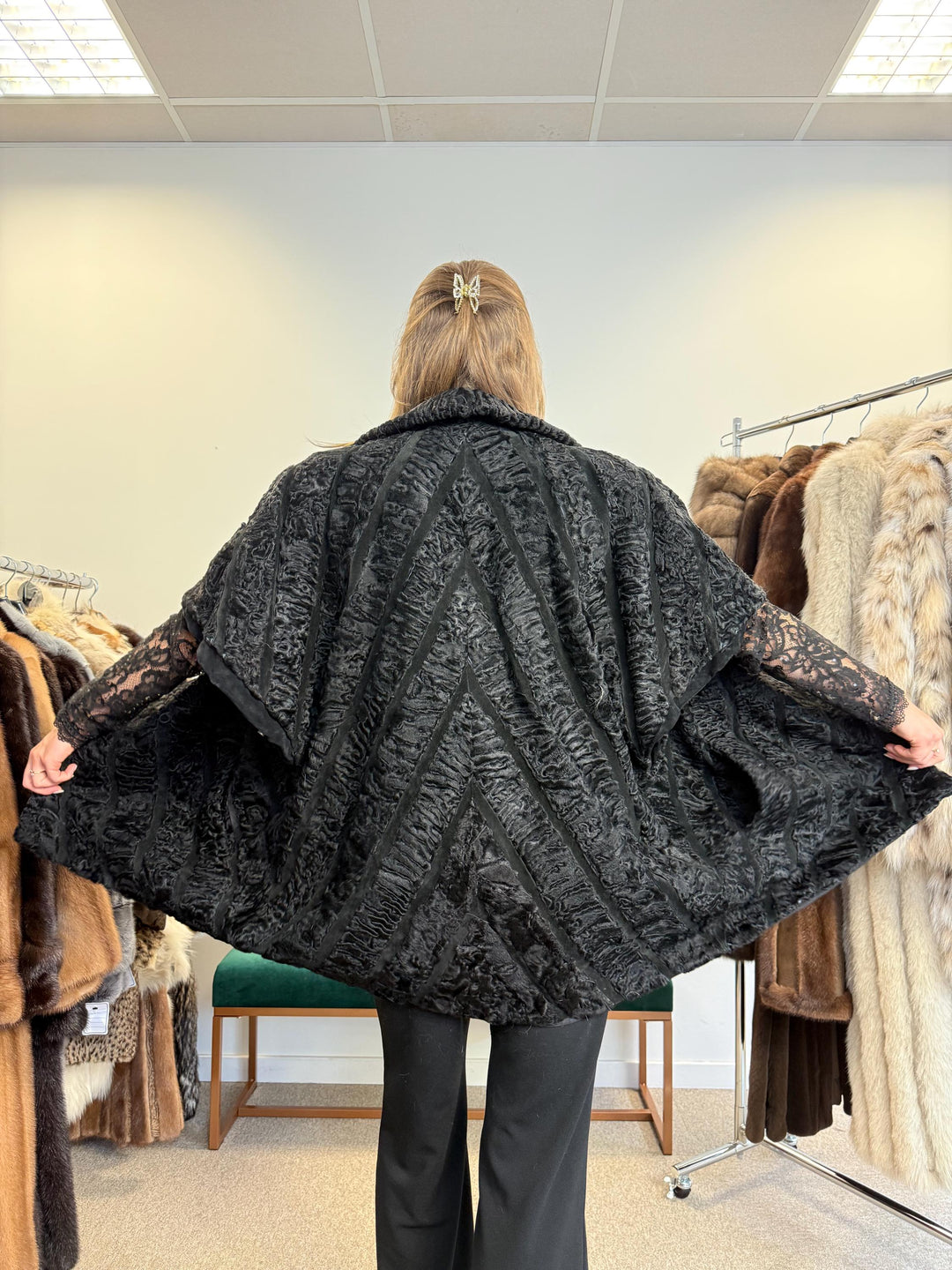 Close-up of black astrakhan fur texture, soft high-quality real fur, women’s vest