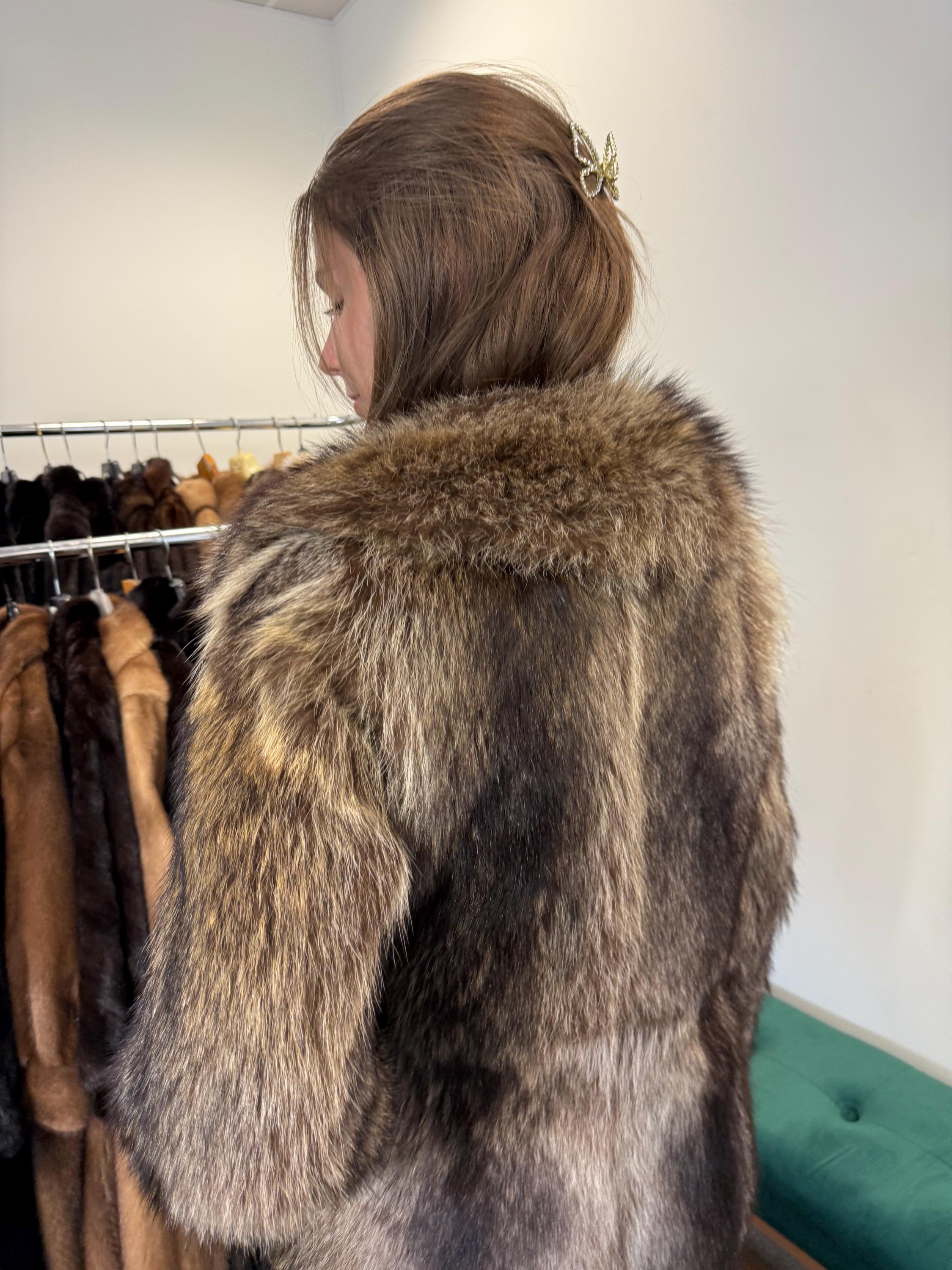 Shoulder and sleeve detail of raccoon fur jacket, women’s soft real fur.