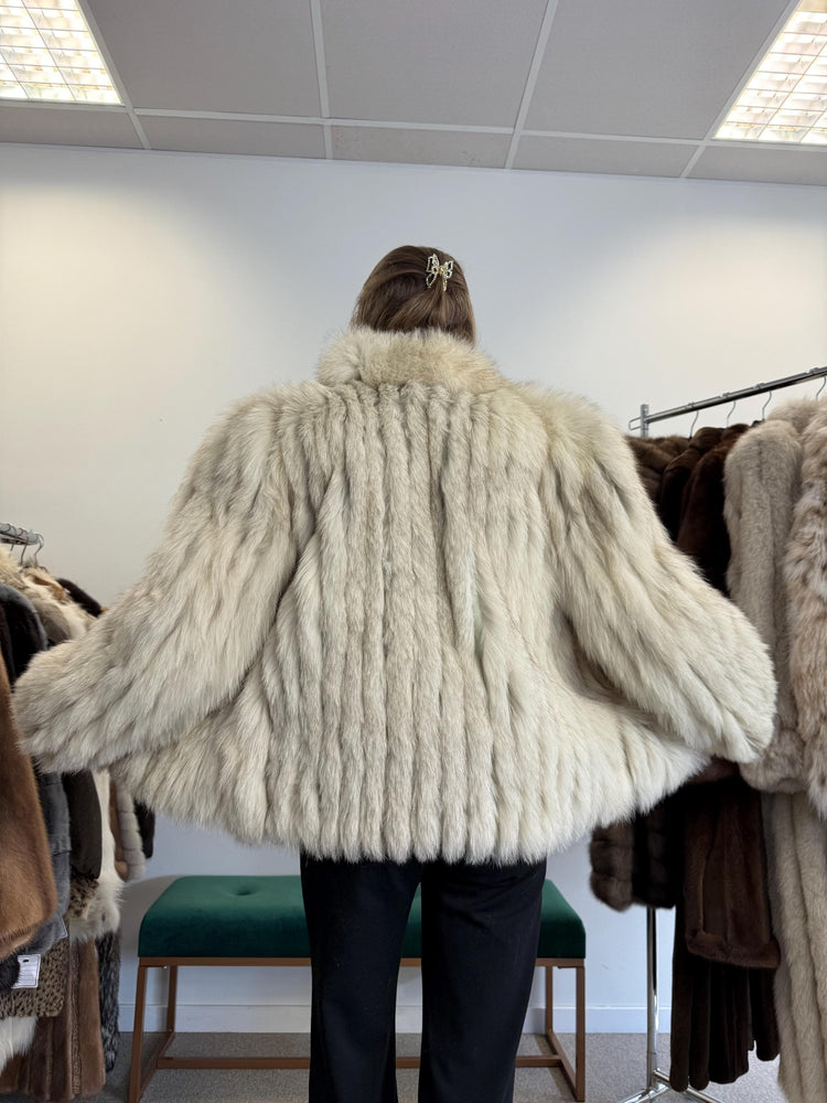 Close-up of Saga Fox fur texture, soft white and blue natural fur, medium women’s jacket.